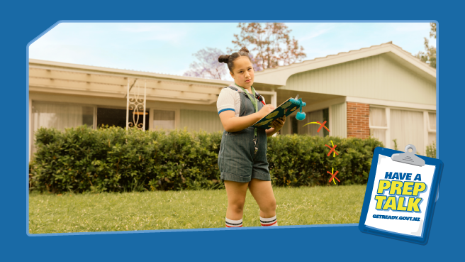 A young girl with a clipboard in front of a house stares down the viewer. Arrows are drawn on the ground to show the best evacuation route. In the corner is a clipboard that says Have a Prep talk getready.govt.nz