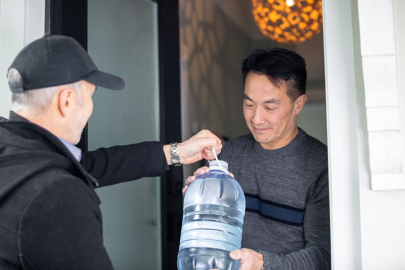 Man giving his neighbour a large bottle of water