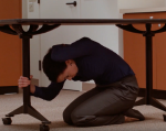 Woman doing Drop, Cover and Hold under a table